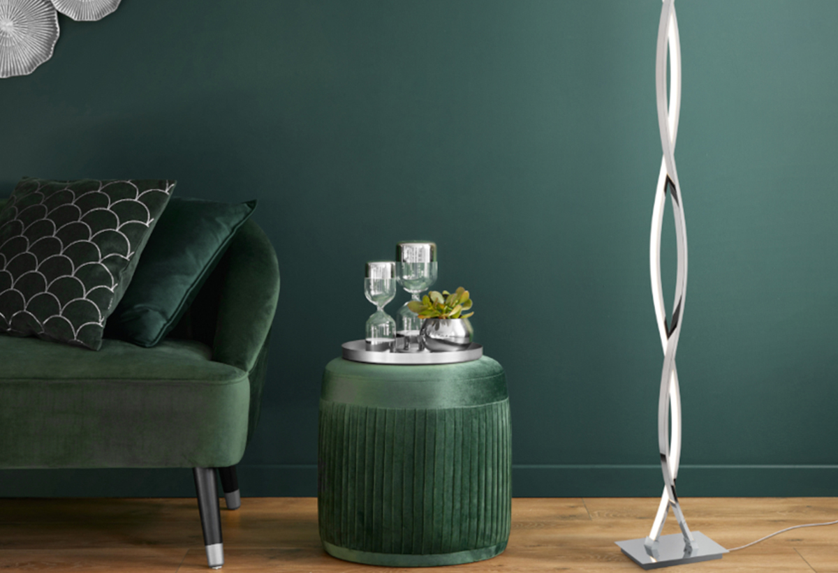Παρουσιάζει το φωτιστικό τοποθετημένο σε ένα σαλόνι με καναπέ σε πράσινη απόχρωση